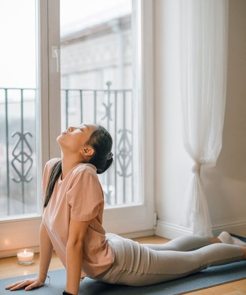 Woman peacefully stretching her neck with closed eyes, feeling relaxed.